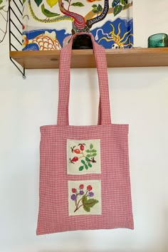 a red and white tote bag hanging from a shelf