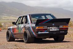 an old bmw is parked in the dirt