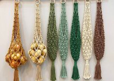 several tassels are hanging on the wall with gold balls in them and green cords