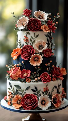 a multi layer cake decorated with flowers and leaves