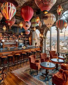 the interior of a restaurant with many hot air balloons hanging from the ceiling and tables