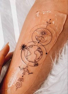 a woman's arm with a tattoo on it that has the earth and stars