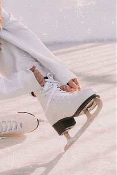 a woman sitting on top of a skateboard next to another person wearing white shoes