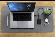 an open laptop computer sitting on top of a desk next to a plant and headphones