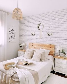 a bedroom with white brick walls and wooden headboard