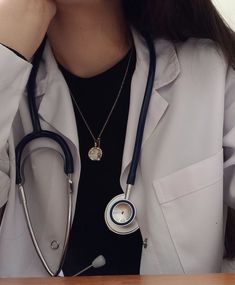 a woman wearing a stethoscope and holding her hand up to her face