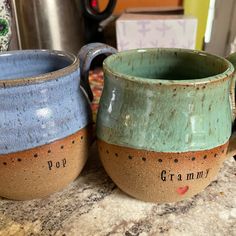 two coffee mugs sitting next to each other on a counter