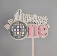 a cake topper that says marvelous one with a disco ball