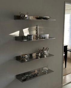 three metal shelves on the wall in a room