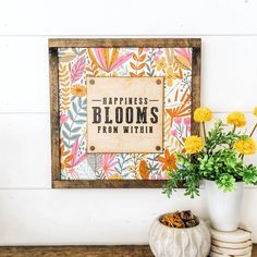 there is a vase with yellow flowers next to a sign that says happiness blooms from within