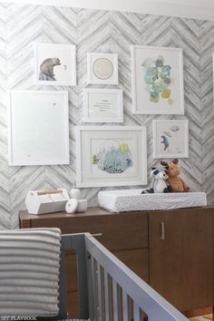 a baby's room with pictures on the wall