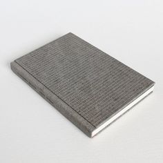 a gray book sitting on top of a white table