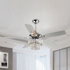 a white ceiling fan with crystal chandelier hanging from it's blades in a bedroom