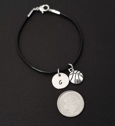 "Personalized Waxed Cord Bracelet! A Basketball charm on a black waxed cord makes the perfect gift for you or your best friend. The basketball charm is made from zinc alloy and measures 13 mm by 10 mm. The charm is not reversible. The basketball bracelet is a waxed braided rope and measures 7.25\" with a 1-2\" extender (see last picture). The lobster clasp is zinc alloy. The black cord bracelet can be personalized with a .5\" silver plated disc stamped with the initial of your choice. Each perso Nickel-free Black Charm Bracelet For Gift, Nickel-free Black Charm Bracelet As Gift, Adjustable Nickel-free Black Charm Bracelet, Adjustable Black Bracelets With Charms, Black Waxed Cord Jewelry For Friendship, Nickel-free Black Charm Bracelet, Black Nickel-free Charm Bracelet, Gift Leather Bracelet With Adjustable Waxed Cord, Adjustable Nickel-free Bracelets With Waxed Cord