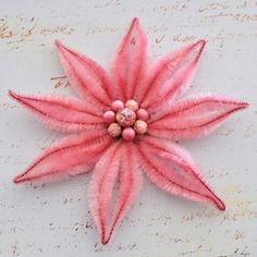 a pink flower on top of a piece of paper