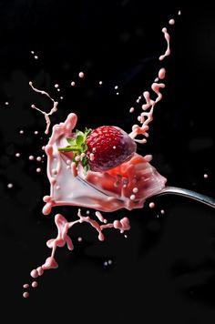 a spoon full of milk and strawberries with pink sprinkles