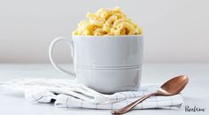 a white bowl filled with macaroni and cheese sitting on top of a table