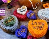 several crocheted hearts with the word hope written on them sitting next to a purse