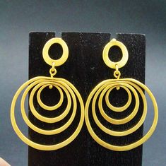 Add a touch of elegance to any outfit with these stunning 18kt gold-plated earrings, nickel free. Featuring delicate and intricate moving circles, these earrings are the perfect gift for any special woman in your life. The design is both unique and eye-catching, making them a must-have for any jewelry collection. The dangle style adds a subtle movement and sparkle, making these earrings perfect for any occasion. Whether you're looking for a gift for your wife or a special treat for yourself, the Gold Circular Earrings For Wedding, Elegant Gold-tone Circular Earrings, Luxury Brass Earrings With Intricate Design, Gold Swirl Metal Earrings, Semi-circle Brass Earrings For Gifts, Elegant Semi-circle Brass Earrings, Gold Semi-circle Brass Earrings, Sea Jewelry, Gold Plated Earrings