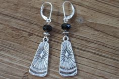 "These boho dangle earrings feature beautiful black czech glass beads hanging from sterling silver leverback and sterling silver head pins. Plus, they're made with antique silver plated ethnic charm (28x12mm), giving them a unique rustic look. At just 2-1/4 inches long, these earrings are the perfect accessory for any outfit. Color : Black faceted czech glass beads Finish : Sterling Silver lever back, Sterling Silver head pins, Antique Silver plated ethnic charm (28x12mm) and antique silver plat Boho Silver Earrings, Black Boho, Black Jewelry, Head Pins, Bohemian Earrings, Earrings Black, Earrings Drop, Silver Earrings Dangle, Glass Earrings