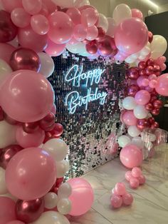 balloons and streamers are on the floor in front of a sign that says happy birthday