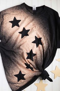 a t - shirt with black stars on it and some gold stars next to it