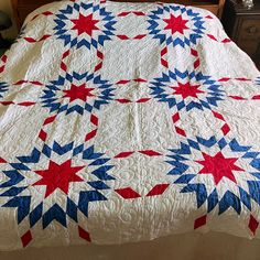 a quilted bed with red, white and blue stars on the cover is shown