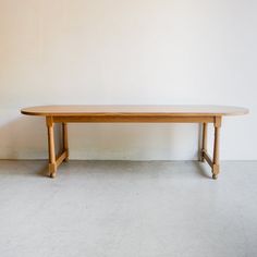 a wooden table sitting on top of a white floor next to a wall with no people