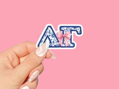 a woman's hand holding up a sticker with the letter a on it