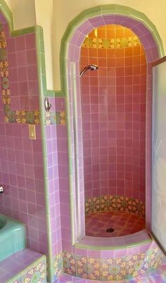 a bathroom with pink and green tiles on the walls