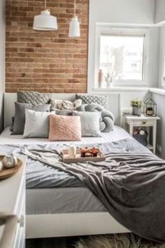 a bedroom with brick walls and white furniture