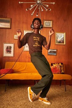 a man wearing headphones standing in front of a couch