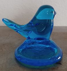 a blue glass bird sitting on top of a table