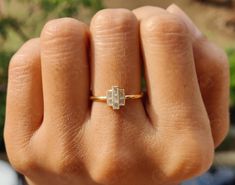 a person's hand with a gold ring on top of their finger and a diamond in the middle