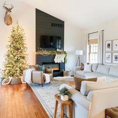 a living room filled with furniture and a christmas tree in front of a fire place