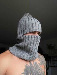 a man wearing a gray knitted hood and neck scarf with his face covered by a mask