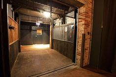 an open door leading into a dark room with brick walls and doors on both sides