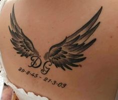 the back of a woman's shoulder with an angel wing tattoo on her left side