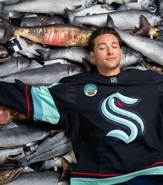 a man laying on top of a pile of fish