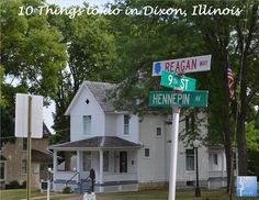 two street signs in front of a white house