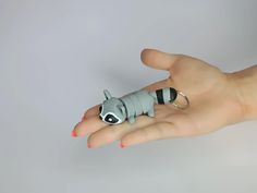 a person's hand holding a small toy animal