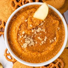 a white bowl filled with food next to pretzels