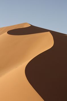 two people are walking in the sand dunes