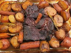 a tray filled with meat, potatoes and carrots