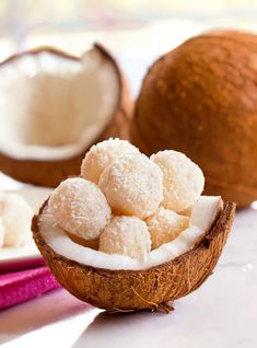 coconuts and sugar are sitting on the table next to each other, with one cut in half