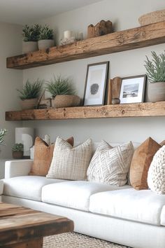 a living room filled with lots of white furniture and plants on top of wooden shelves