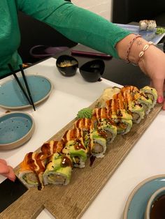 sushi rolls are being served on a wooden platter