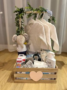 a wooden crate filled with baby items on top of a hard wood floor