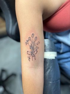 a woman's arm with a tattoo on it that has flowers in the middle