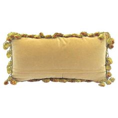 a tan pillow with pom poms on it